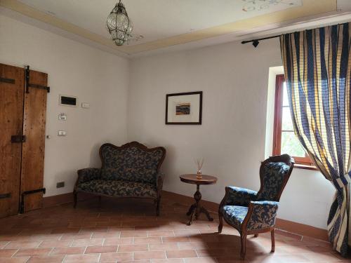 a living room with a chair and a table at Villa Curina Resort in Castelnuovo Berardenga