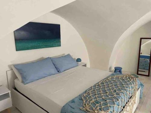 Un dormitorio con una cama y un cuadro en la pared. en Gentile Cottege, en Matino