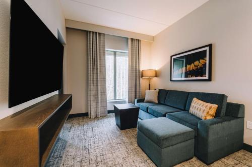 a living room with a couch and a flat screen tv at Embassy Suites By Hilton Gatlinburg Resort in Gatlinburg