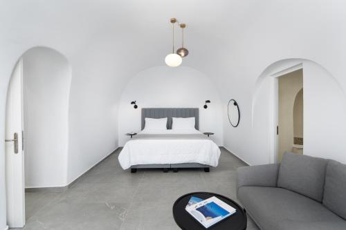 a bedroom with a bed and a couch at Petit Palace Suites in Fira