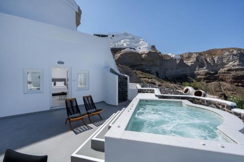 a villa with a swimming pool on the roof at Petit Palace Suites in Fira