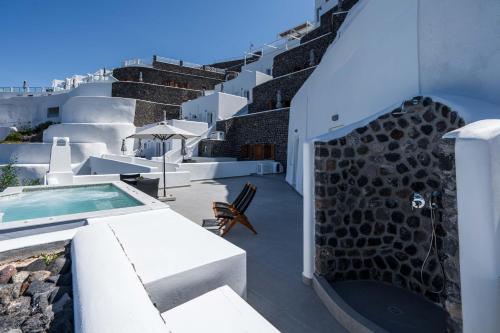 a house with a swimming pool on a roof at Petit Palace Suites in Fira