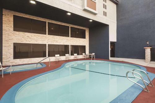 a large swimming pool in front of a building at Country Inn & Suites by Radisson, Bakersfield, CA in Bakersfield