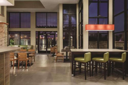 a restaurant with tables and chairs and windows at Country Inn & Suites by Radisson, Bakersfield, CA in Bakersfield