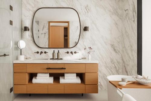 La salle de bains est pourvue d'un lavabo et d'un miroir. dans l'établissement One&Only Aesthesis, à Athènes