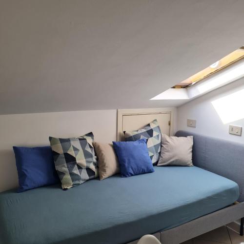 un sofá azul con almohadas en una habitación en Gate 25 en San Giovanni Teatino