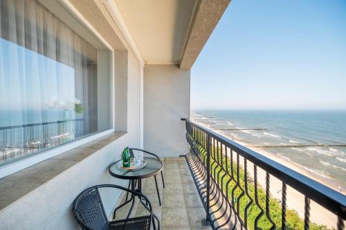 a balcony with a table and a view of the ocean at Hotel Wodnik Twój Hotel z widokiem na morze in Ustronie Morskie