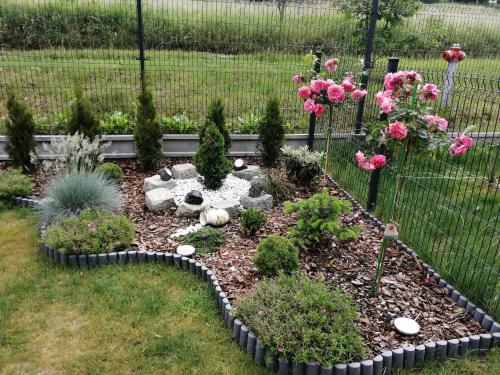 a garden with pink flowers and a fence at Apartament Zielone Wzgórze 2 in Jelenia Góra