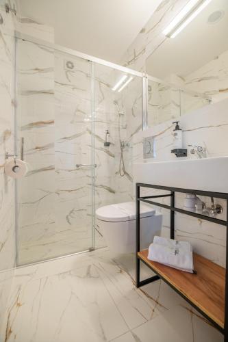 a bathroom with a shower and a toilet and a sink at Hotel Wodnik Twój Hotel z widokiem na morze in Ustronie Morskie