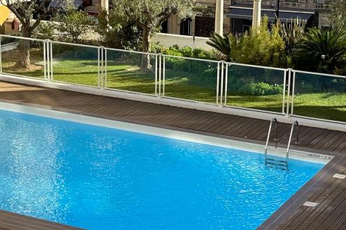 une clôture autour d'une piscine d'eau bleue dans l'établissement Nice Proche Mer, à Nice