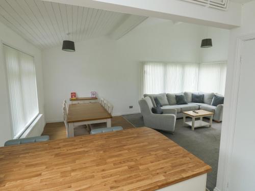 a living room with a couch and a table at Harcombe House Bungalow 1 in Newton Abbot
