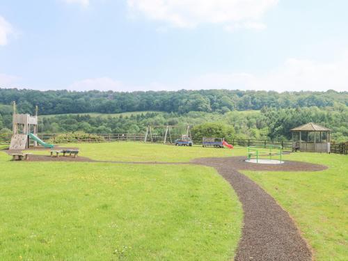 a park with a playground and a bench at Harcombe House Bungalow 1 in Newton Abbot