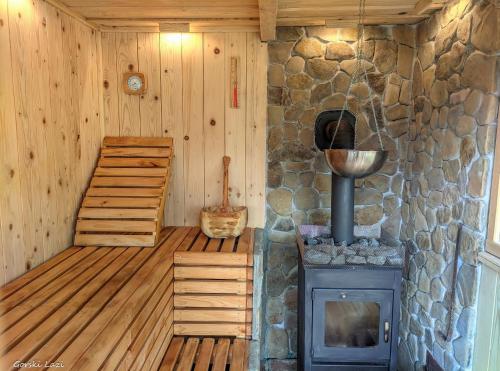 a room with a stove and a stone wall at Tree House Gorski Lazi in Tršće