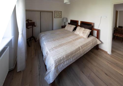 a bedroom with a large bed with a wooden floor at 75 m2 Apartment - Private House in Rumia