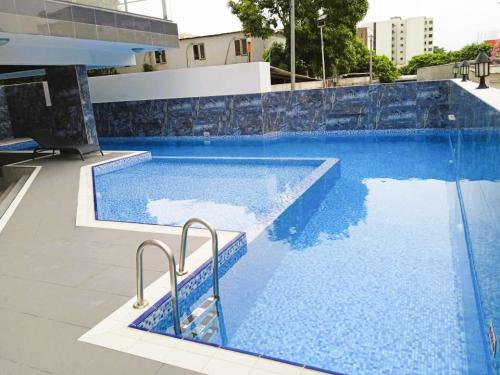une piscine à l'eau bleue dans un immeuble dans l'établissement Prodige meublées, à Abidjan