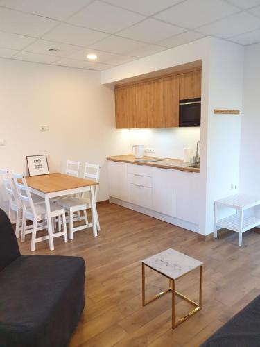 un soggiorno con tavolo e cucina di Apartamenty siostra i siostra a Łaziska