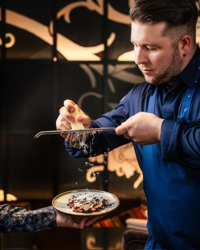 a man is holding a plate of food at Arctic Light Hotel in Rovaniemi