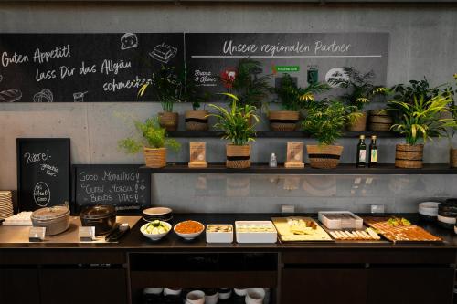 a counter with food and plants in a restaurant at das flax allgäu in Dietmannsried