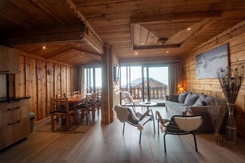 un salon avec un canapé, une table et des chaises dans l'établissement Les Chalets du Thorens, à Val Thorens