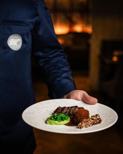 a person holding a plate with food on it at Arctic Light Hotel in Rovaniemi