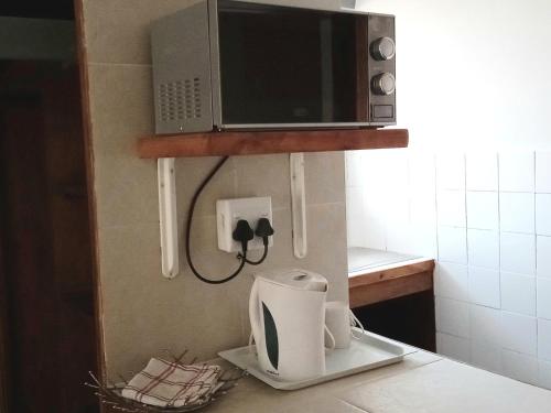 a kitchen with a microwave and acomputer on a counter at Stay @ Edison in Strand