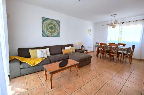 sala de estar con sofá y mesa en CASA MARTA duplex con piscina privada en Corralejo, en Corralejo