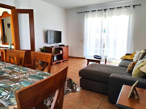 sala de estar con sofá y TV en CASA MARTA duplex con piscina privada en Corralejo, en Corralejo