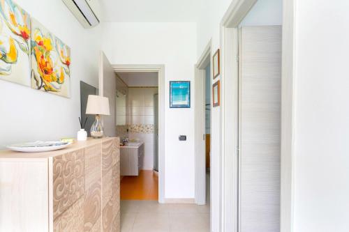 a white kitchen with a counter and a bathroom at Appartamento di Stefy by BarbarHouse in Torre Lapillo