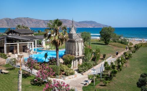 an aerial view of a resort with a swimming pool and the ocean at Orpheas Resort Hotel (Adults Only) in Georgioupolis