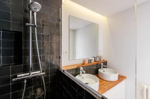 une salle de bain avec un lavabo et un miroir dans l'établissement Meuniers - Spacieux appartement proche Bois de Vincennes, à Paris