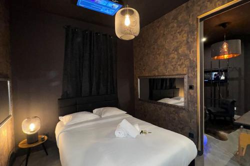 une chambre avec un grand lit blanc et un miroir dans l'établissement love Room claire 1, à Lyon