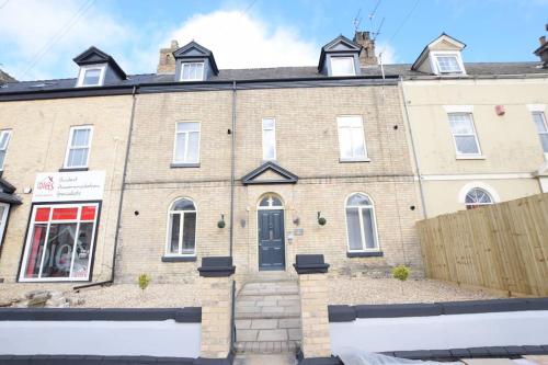 a large brick house with a fence in front of it at Stylish city centre 1 bed apartment in Lincolnshire