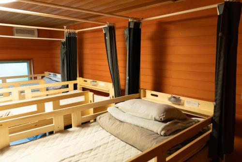 Postel nebo postele na pokoji v ubytování 木の家ゲストハウス