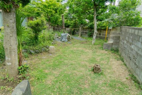 an empty yard with a fence and trees at 木の家ゲストハウス in Mito