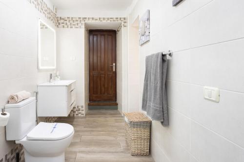 a white bathroom with a toilet and a sink at Home2Book Cozy Rustic House & Terrace, El Pinar in Taibique