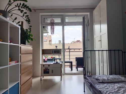 a bedroom with a bed and a desk and a window at Blue Sky Apartment in Poznań
