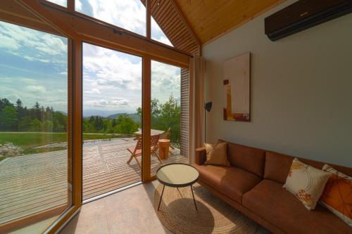 a living room with a couch and a view of a deck at Glamping Zarja, Vipava Valley in Zoll