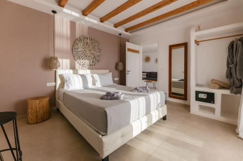 Naxos Finest Hotel & Villas في ناكسوس تشورا: غرفة نوم مع سرير أبيض كبير في غرفة