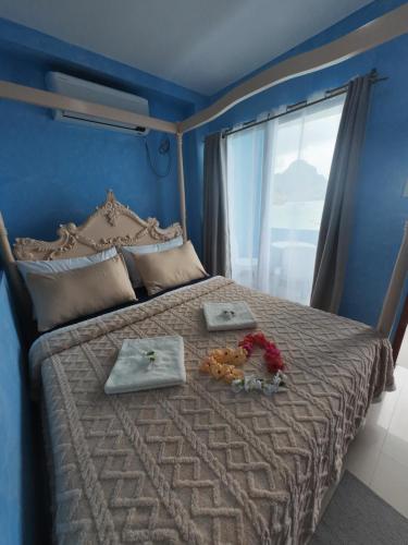 a bedroom with a bed with a large window at La Salangane Beach Hotel - Downtown in El Nido