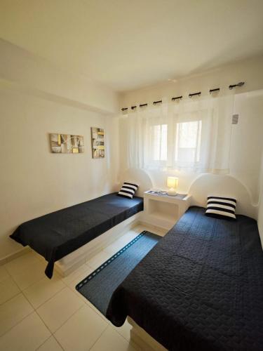 a room with two beds and a window at Aldea de Meer in Torrevieja