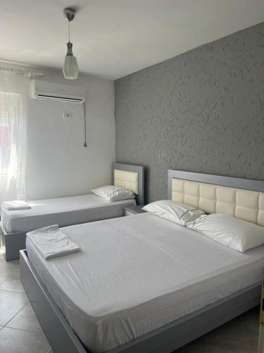 a bedroom with two beds and a window at Red Sunset Apartment in Himare