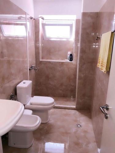 a bathroom with a toilet and a shower and a sink at Red Sunset Apartment in Himare