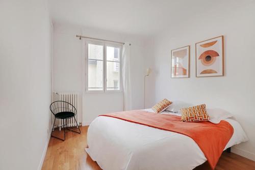 une chambre blanche avec un grand lit et une fenêtre dans l'établissement Lumineux 2 pièces Batignolles, à Paris