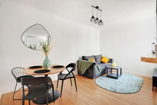 un salon avec une table, des chaises et un canapé dans l'établissement Lumineux 2 pièces Batignolles, à Paris