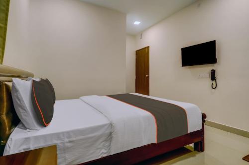 a bedroom with a bed and a tv on the wall at Super Collection O Halcyon Madhapur in Hyderabad