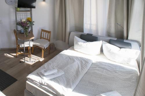 a bedroom with a bed with a table and a chair at Apartments am Schlosspark in Senftenberg