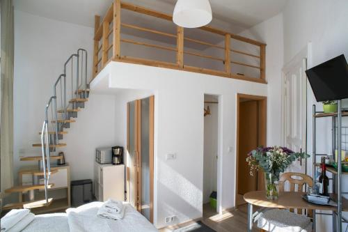 a living room with a spiral staircase and a table at Apartments am Schlosspark in Senftenberg