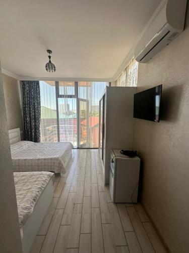 a hotel room with two beds and a flat screen tv at My House in Batumi