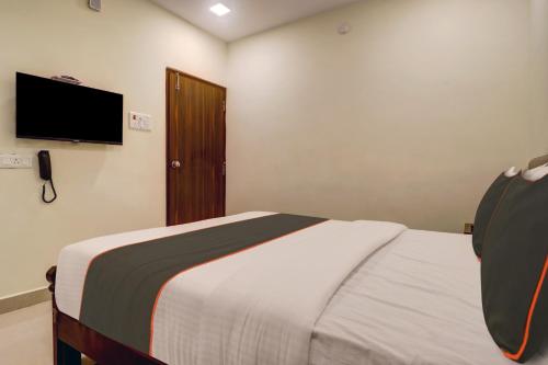 a bedroom with a bed and a flat screen tv at Super Collection O Halcyon Madhapur in Hyderabad