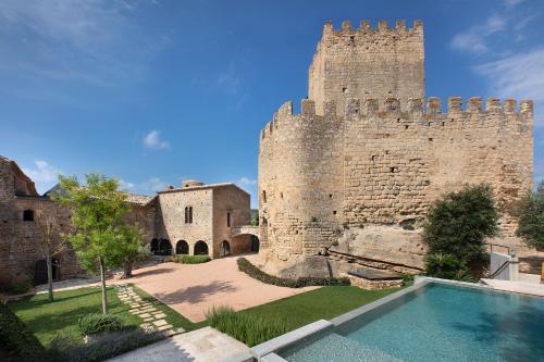 Deco - Casa Castell de Peratallada في بيرتايادا: قلعة أمامها مسبح